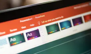 Schermo di un laptop con una presentazione PowerPoint aperta. Si vedono miniature di diapositive colorate e la barra degli strumenti.