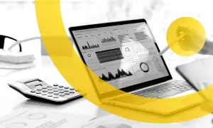 Un laptop mostra un dashboard di vendita, con grafici e dati. Una calcolatrice è accanto. I marketers Dario Vignali analizzano i dati.