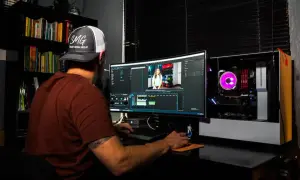 Uomo con cappellino SMG impegnato in un corso di editing video, lavora su un computer con software di montaggio.