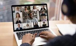 Schermo di un laptop con una videoconferenza in corso, mostrando volti sorridenti di persone che partecipano a eventi digitali.