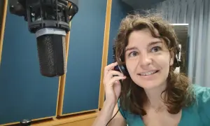 Roberta Fulci in uno studio di registrazione, con cuffie e microfono, pronta per una sessione vocale.
