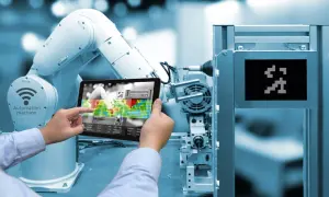 Un braccio robotico e un tablet mostrano l'interfaccia di una macchina automatizzata, illustrando cos'è l'industria 4.0.