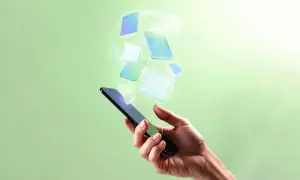Mano che tiene uno smartphone, con icone digitali che fluttuano verso l'alto, evocando la gestione di contenuti WordPress mobile.