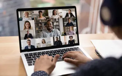 Schermo di un laptop con una videoconferenza in corso, mostrando volti sorridenti di persone che partecipano a eventi digitali.