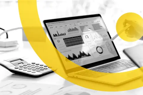 Un laptop mostra un dashboard di vendita, con grafici e dati. Una calcolatrice è accanto. I marketers Dario Vignali analizzano i dati.