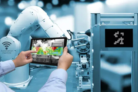Un braccio robotico e un tablet mostrano l'interfaccia di una macchina automatizzata, illustrando cos'è l'industria 4.0.