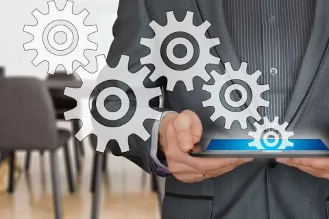 Uomo in giacca e cravatta con ingranaggi che simboleggiano il successo del business online.