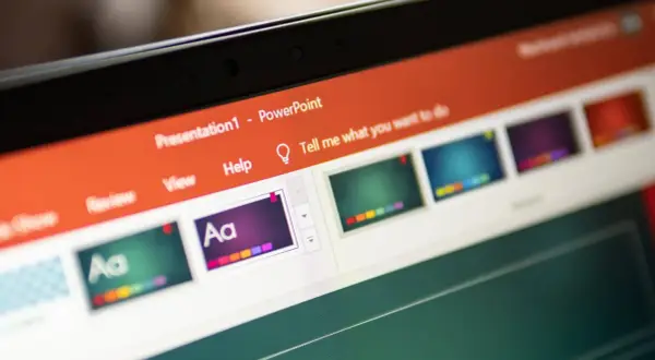 Schermo di un laptop con una presentazione PowerPoint aperta. Si vedono miniature di diapositive colorate e la barra degli strumenti.