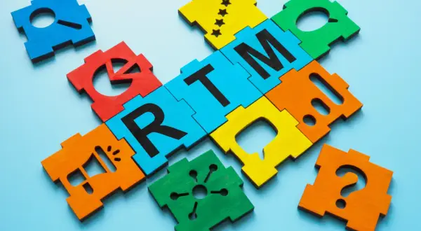 Pezzi colorati del puzzle formano la parola "RTM", con icone di marketing come megafono e punto interrogativo.
