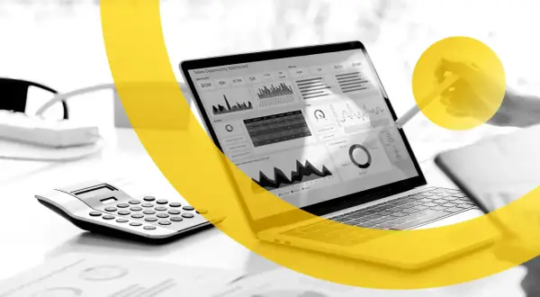 Un laptop mostra un dashboard di vendita, con grafici e dati. Una calcolatrice è accanto. I marketers Dario Vignali analizzano i dati.