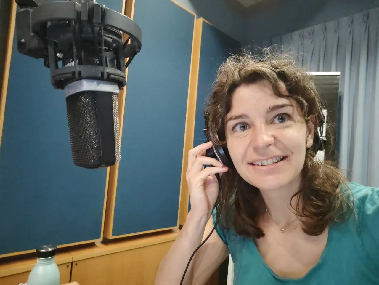 Roberta Fulci in uno studio di registrazione, con cuffie e microfono, pronta per una sessione vocale.