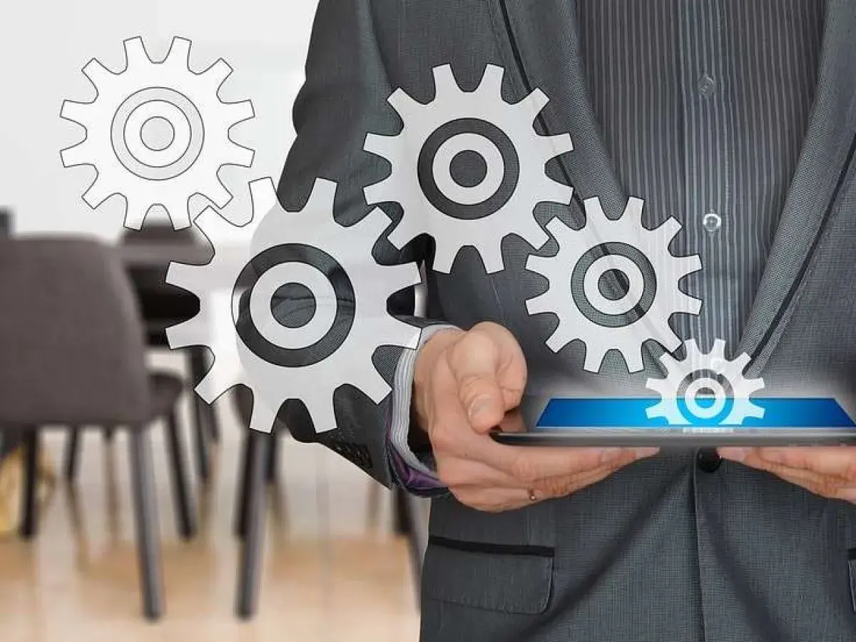 Uomo in giacca e cravatta con ingranaggi che simboleggiano il successo del business online.
