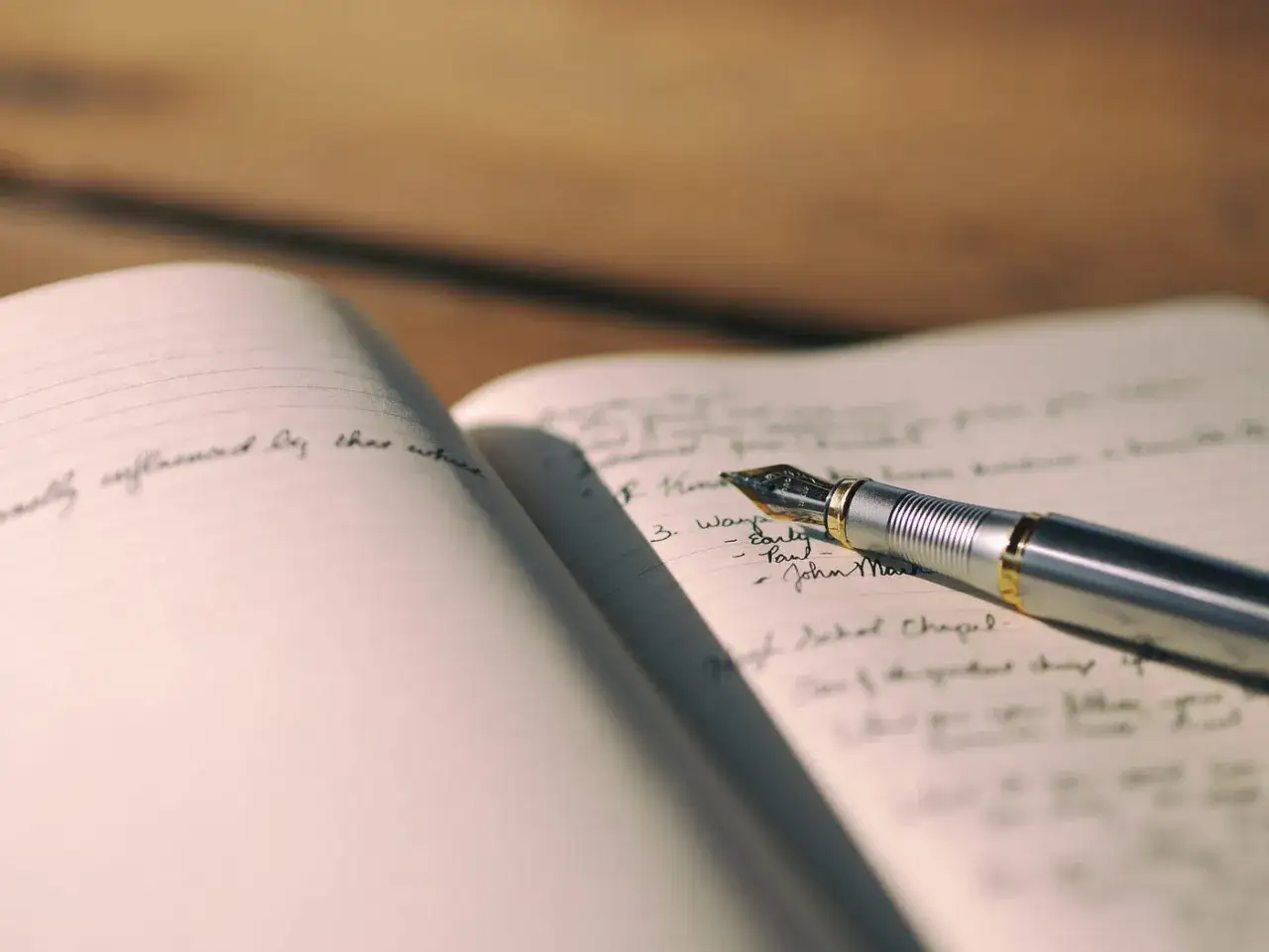 Penna stilografica su taccuino aperto, con appunti scritti a mano. Un'ispirazione per chi studia libri sul copywriting.